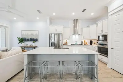 a kitchen with a large island with bar stools at Blue Dreams 125 W Pine Lands Loop Unit A in Inlet Beach