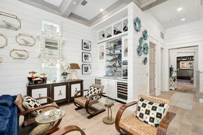 a living room with white walls and chairs and a table at Gulf Royale 30A in Inlet Beach
