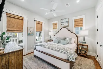a bedroom with a bed and two windows at Beach Heaven in Inlet Beach