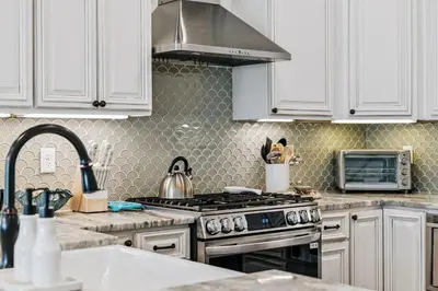 a kitchen with white cabinets and a stove top oven at Beach Heaven in Inlet Beach