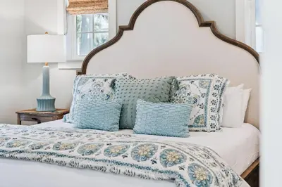 a bedroom with a bed with blue and white pillows at Beach Heaven in Inlet Beach