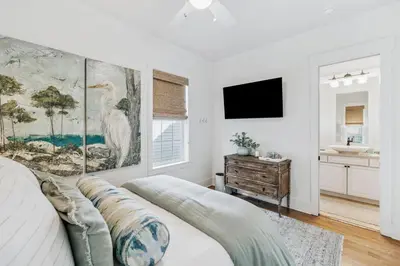 a white bedroom with a large painting on the wall at Beach Heaven in Inlet Beach