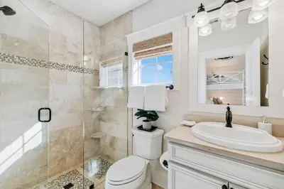 a bathroom with a toilet and a sink and a shower at Beach Heaven in Inlet Beach