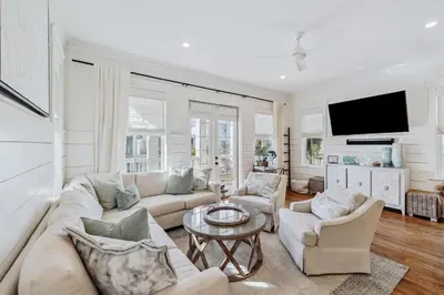 a living room with a couch and chairs and a tv at Beach Heaven in Inlet Beach