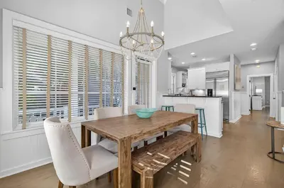 a kitchen and dining room with a wooden table and chairs at 231 Saltbox Lane - Near Beach Home with Community Pool in Watersound in Watersound Beach