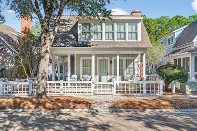 a house with a white fence and a tree at 231 Saltbox Lane - Near Beach Home with Community Pool in Watersound in Watersound Beach