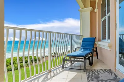 a blue chair on a balcony with a view of the ocean at 30A Monterey B201 - Gulf Front Condo Near Alys Beach in Seacrest