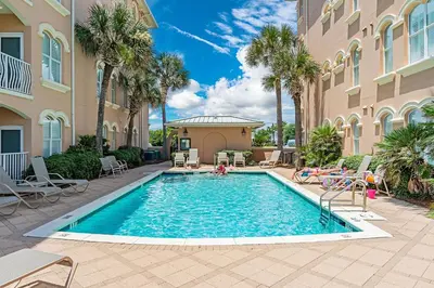 a swimming pool in front of a building with palm trees at 30A Monterey B201 - Gulf Front Condo Near Alys Beach in Seacrest