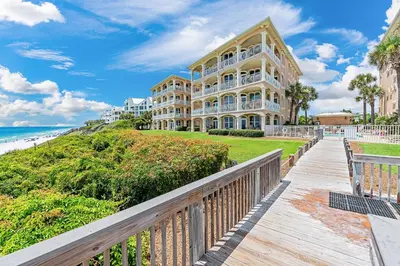 a building on a boardwalk next to the beach at 30A Monterey B201 - Gulf Front Condo Near Alys Beach in Seacrest