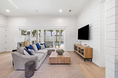 a living room with a couch and a tv at 30A Backyard Paradise - Huge Luxury Vacation Home with Gulf Views & Private Pool in Rosemary Beach