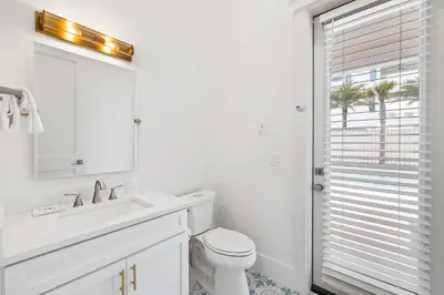 a white bathroom with a sink and a toilet at 30A Backyard Paradise - Huge Luxury Vacation Home with Gulf Views & Private Pool in Rosemary Beach