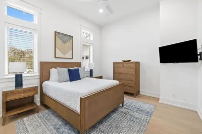 a bedroom with a bed and a flat screen tv at 30A Backyard Paradise - Huge Luxury Vacation Home with Gulf Views & Private Pool in Rosemary Beach
