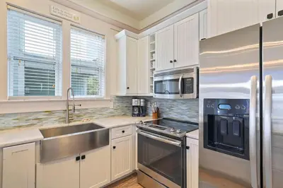 a kitchen with white cabinets and a stainless steel appliances at Arrabella - Gulf Views with Deck & Community Pool in Santa Rosa Beach