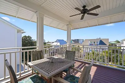 a porch with a table and chairs and a ceiling fan at Arrabella - Gulf Views with Deck & Community Pool in Santa Rosa Beach