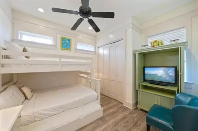 a bedroom with bunk beds and a flat screen tv at Arrabella - Gulf Views with Deck & Community Pool in Santa Rosa Beach