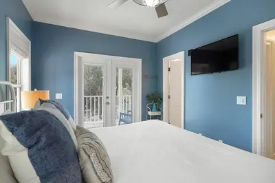 a blue bedroom with a bed and a tv at Beach Baby - Secluded Home with Private Pool Area & Deck in Santa Rosa Beach