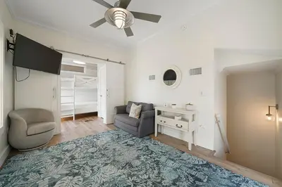 a living room with a ceiling fan and a chair and a desk at Beach Baby - Secluded Home with Private Pool Area & Deck in Santa Rosa Beach