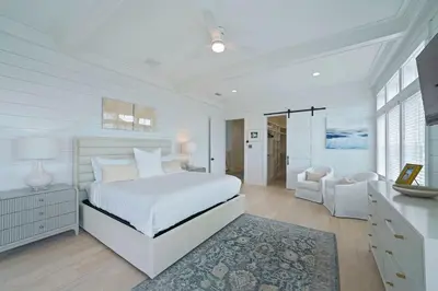a white bedroom with a bed and a desk at Big Gus - Huge Home Near the Beach with Gulf Views & Secluded Pool Area in Rosemary Beach