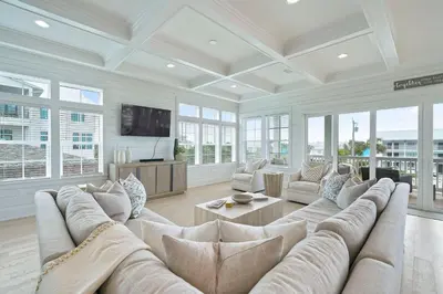 a large living room with a large couch and a tv at Big Gus - Huge Home Near the Beach with Gulf Views & Secluded Pool Area in Rosemary Beach