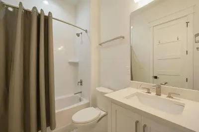 a white bathroom with a sink and a toilet at Big Gus - Huge Home Near the Beach with Gulf Views & Secluded Pool Area in Rosemary Beach