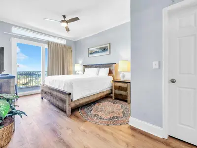 a bedroom with a bed and a balcony at Laketown Wharf 2031 in Panama City Beach