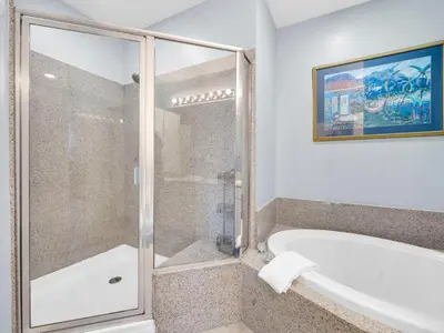 a bathroom with a bath tub and a shower stall at Laketown Wharf 2031 in Panama City Beach