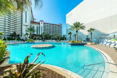a large swimming pool with palm trees and buildings at Laketown Wharf 2031 in Panama City Beach