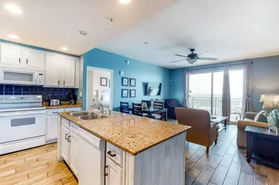 a kitchen with a counter top and a living room at Sterling Reef 505 by Emerald Coast Retreats in Panama City Beach