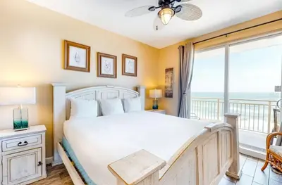 a bedroom with a bed and a balcony at Sterling Reef 505 by Emerald Coast Retreats in Panama City Beach