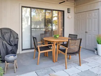 a wooden table and chairs on a patio at Cassine Gardens #270 - The Getaway in Santa Rosa Beach