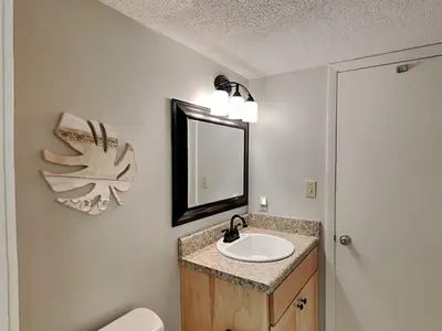 a bathroom with a sink and a mirror at Dunes of Panama #D705 in Panama City Beach