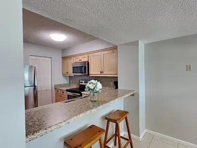a kitchen with a vase of flowers on a counter at Dunes of Panama #D705 in Panama City Beach