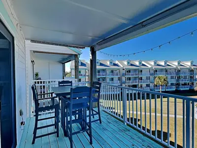 a deck with a table and chairs on a balcony at Treasure Cove #D308 - Paradise City in Panama City Beach