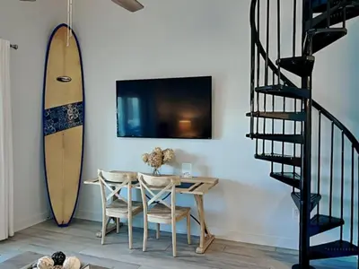 a dining room with a table and a surfboard at Treasure Cove #D308 - Paradise City in Panama City Beach