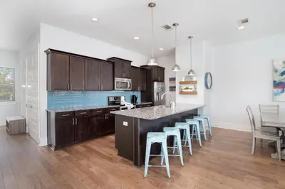 a kitchen with wooden cabinets and a counter with bar stools at Seacrest Paradise Spacious 4 bedroom retreat in Inlet Beach, perfect for 13 guests in Inlet Beach