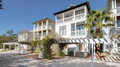 a white building with a palm tree in front of it at Experience luxury at Doctor in Inlet Beach
