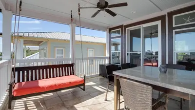 a screened in porch with a bench and a table at Experience luxury at Doctor in Inlet Beach
