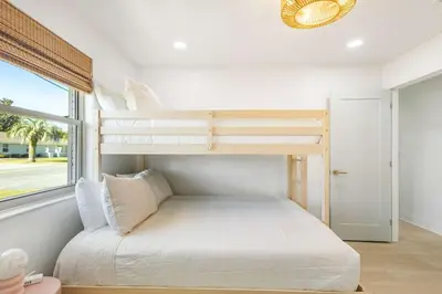 a bedroom with two bunk beds and a window at Sol Haus Stylish Coastal Retreat 3 Blocks to Beach Screened Porch Fast Wi Fi in Panama City Beach