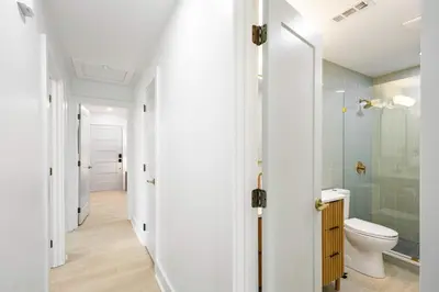 a bathroom with a toilet and a glass shower at Sol Haus Stylish Coastal Retreat 3 Blocks to Beach Screened Porch Fast Wi Fi in Panama City Beach