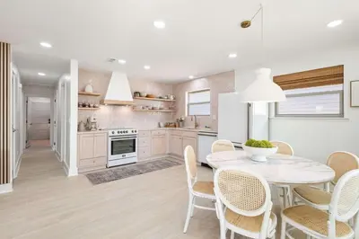 a kitchen with a white table and chairs at Sol Haus Stylish Coastal Retreat 3 Blocks to Beach Screened Porch Fast Wi Fi in Panama City Beach