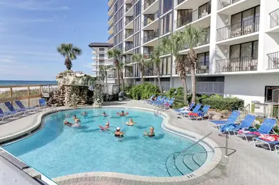 a group of people in a swimming pool at a resort at Billie Jean’s Bungalow! Cozy Edgewater Condo w/ Resort Amenities, Sleeps 6 in Panama City Beach
