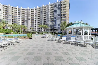 a group of chairs and a gazebo in front of a building at Billie Jean’s Bungalow! Cozy Edgewater Condo w/ Resort Amenities, Sleeps 6 in Panama City Beach