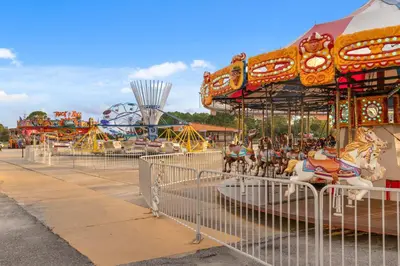 a carousel at a carnival with a roller coaster at Billie Jean’s Bungalow! Cozy Edgewater Condo w/ Resort Amenities, Sleeps 6 in Panama City Beach