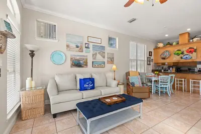 a living room with a couch and a table at Sunset Cove: Charming 3BR/3BA Beach House Sleeps 8 with Sunsets & Serenity in Panama City Beach