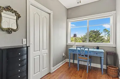 a blue desk in a room with a window at Sunset Cove: Charming 3BR/3BA Beach House Sleeps 8 with Sunsets & Serenity in Panama City Beach