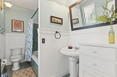 a white bathroom with a sink and a toilet at Sunset Cove: Charming 3BR/3BA Beach House Sleeps 8 with Sunsets & Serenity in Panama City Beach