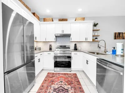 a kitchen with white cabinets and a stainless steel refrigerator at Heron's Watch Way 1102 in Santa Rosa Beach