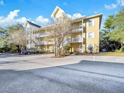 an apartment building with a car parked in front of it at Heron's Watch Way 1102 in Santa Rosa Beach