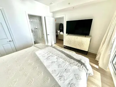 a bedroom with a bed and a flat screen tv at Ocean Reef 1002 in Panama City Beach
