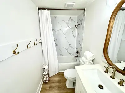 a white bathroom with a toilet and a sink at Ocean Reef 1002 in Panama City Beach
